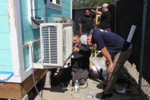 AirTech Team Working on HVAC Unit on Back of House