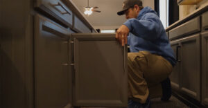 Plumber Working in Kitchen under sink